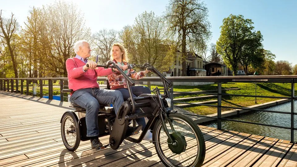 Twee mensen naast elkaar op een DUO-fiets op een brug in Almelo